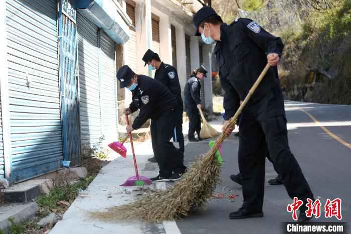 图为边检站民警清扫路边垃圾。　邹兴国 摄