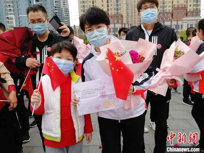 图为3月21日张静静跟随医疗队从黄冈返程时，手里拿着当地小朋友送给她的一幅画。山东大学齐鲁医院供图