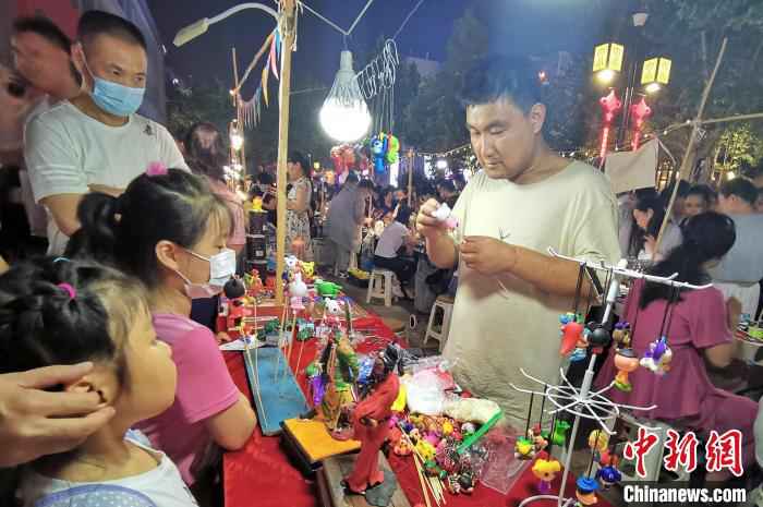 资料图：图为手工艺人在夜晚走上街头，展示面塑工艺。　赵晓 摄