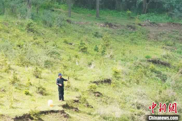 图为山庄村村民从药水泉取完水后用手机记录山中美景。　文思睿 摄