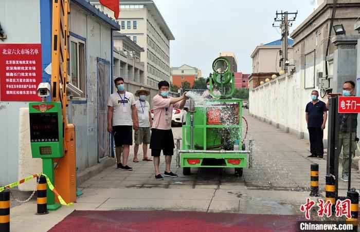 6月18日12时起，河北安新县主要进出通道开始实行交通管制，严控车辆进出城区，县城大部分店铺关闭。图为6月17日，安新县华鼎佳园小区内工作人员进行消毒。/p中新社记者 韩冰 摄