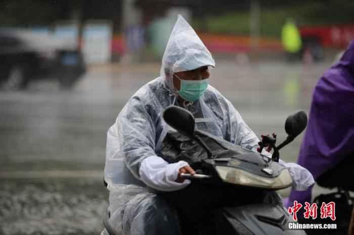 市民冒雨出行。 于海洋 摄