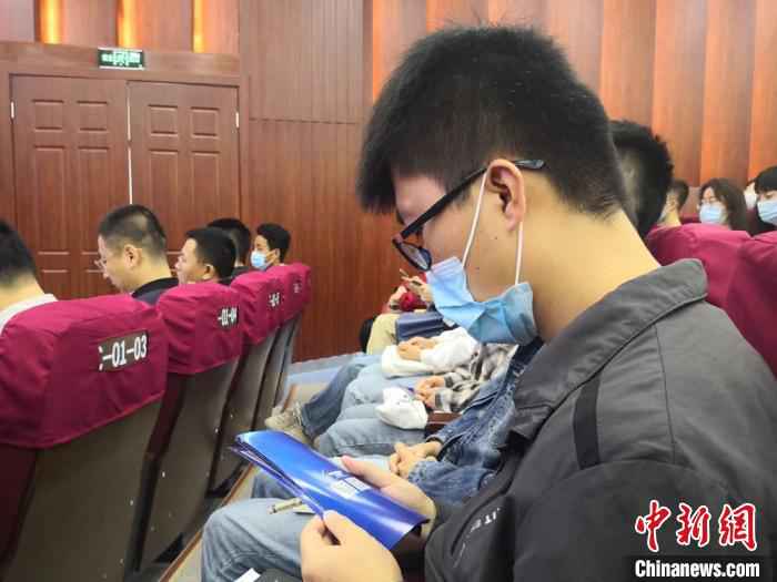 图为参加启动仪式学生学习网络安全知识宣传手册。　杜萍 摄